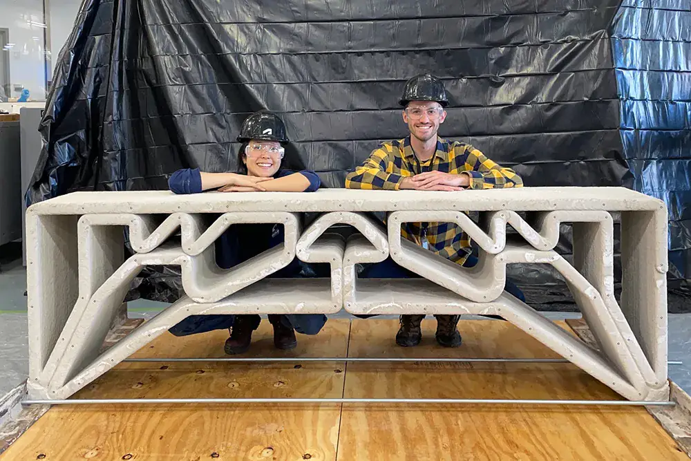Researchers with a small-scale printed concrete bridge prototype.